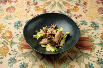 A beautifully arranged plate showcases tender squid grilled to perfection, accompanied by fresh, crisp vegetables