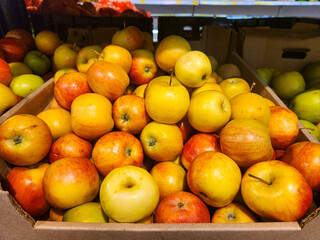 Yellow-red apples in a cardboard box, Fresh apples for sale at the market, Apples store