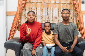 Family Watching Movie Together, Enjoying Snacks, And Reacting With Excitement