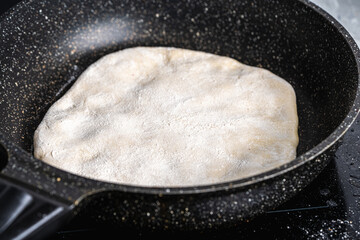 Traditional spanish breakfast potato tortilla. Potatoes in a cast iron frying pan on a rustic wooden background.
