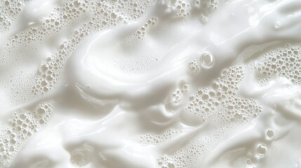 Close-up of creamy white substance with air bubbles, textured surface.