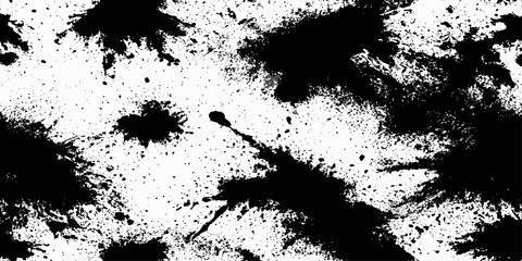 Black ink splatters and spots on a white background creating an abstract and texture dynamic ink. 