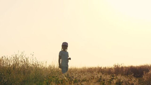 joyful happy running child girls daughters in the countryside, farmer's daughter runs having fun playing, children's dream, children running along a rural road, schoolgirl running into the sunset