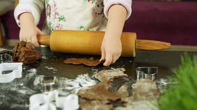 Close-up shot of making gingerbread cookies for Christmas, with child&rsquo;s hands in the kitchen at home