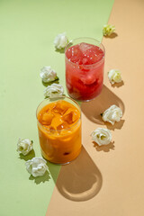 Brightly colored non-alcoholic drinks are artistically arranged, with ice adding a chilled touch