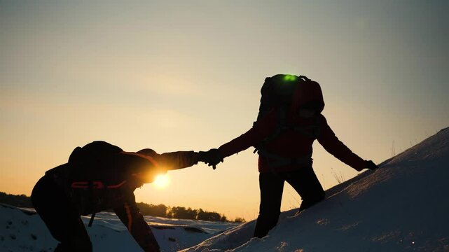 teamwork silhouette. handshake comrades rejoicing victory. shake hands command group mountain hill sunset. overcome difficulties. top cliff goal climbers. trekking snowy winter hike happy successful