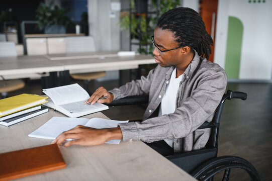Focused african american student in wheelchair studying in library