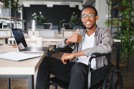 African american student in wheelchair studying at modern workspace