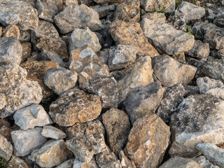 Close-up of natural limestone rocks in warm light. Rough, weathered texture highlights geological detail and natural earth tones. Ideal for backgrounds, geology, and construction themes