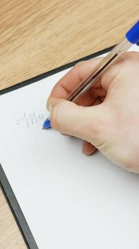Hand writing &ldquo;My plan&rdquo; with a pen on white paper, close-up from above, calm and focused