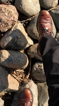 Walking on Rocky Ground: Foot in Shoe Navigating Uneven Surface