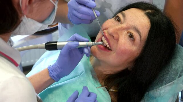 Dentist's assistant raises client's upper lip for dental care