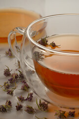 Tea with thyme in a mug on the table.