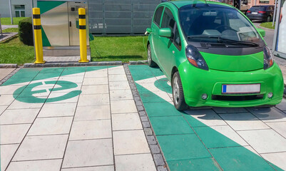 Modern electric car plugged in, charging on the street station. New energy vehicles, environment friendly alternative energy for cars