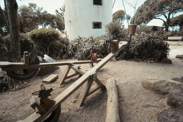 Wooden seesaw with hand-painted animal seats and tire bases in a rustic outdoor playground...