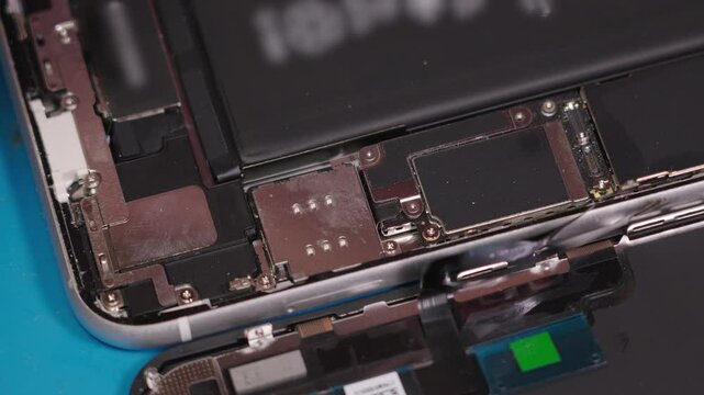 Master technician restores smartphone functionality in detailed repair process at electronics service center