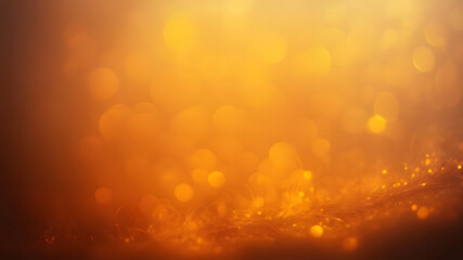 Warm abstract background featuring golden bokeh effects and sparkling particles for designs