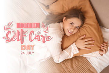 Young pretty woman in pajamas lying on bed and hugging pillow at home