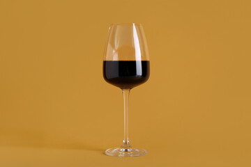 Glass of red wine on orange background