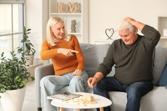 Mature couple playing jenga at home