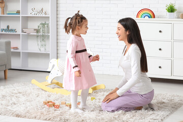 Little girl with teacher learning alphabet at home