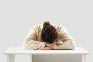 Portrait of worried man at table on light background