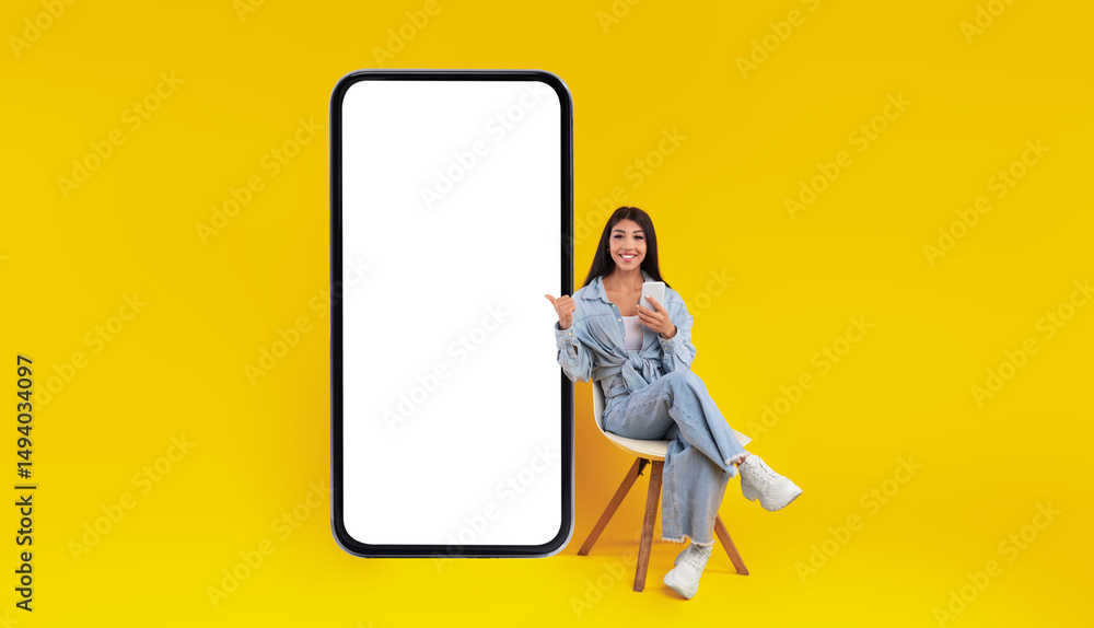 Poster check this. excited lady sitting on chair using cell pointing finger at big giant smart phone with e