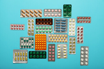 Different pills in blister packs on blue background