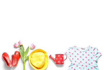 Stylish children's clothes with tulips and watering can on white background