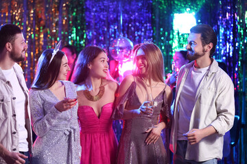 Young people with drinks at party in night club