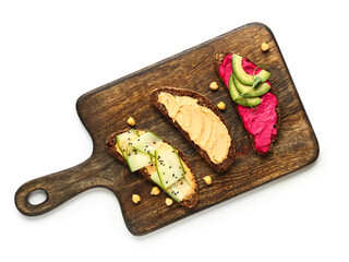 Wooden board of different sandwiches with hummus on white background