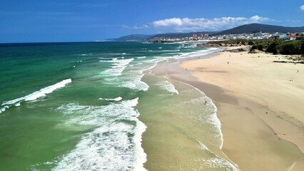 A stunning aerial view of a tranquil beach with vibrant waves gently crashing onshore