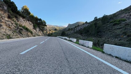 A Beautiful and Scenic Mountain Road Stretching Under a Clear and Expansive Blue Sky Above
