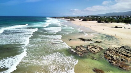 Stunningly Beautiful Aerial View of a Serene Beach with Waves Gently Lapping at the Sandy Shore