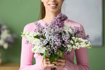 Young woman with lilac flowers at home, closeup
