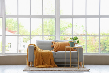Coffee table and sofa near window in interior of living room