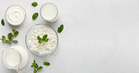 Bowls with curd, sour and jar with milk on white background, top view, copy space. Dairy nutrition concept