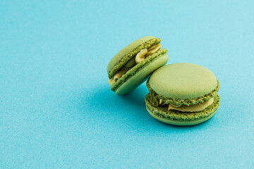 Green macarons on blue background with subtle texture