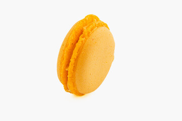 Bright yellow macaron with smooth filling on white background