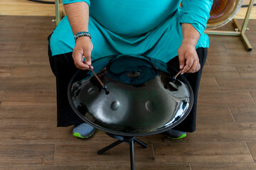 Musician playing handpan drum in music studio for sound healing therapy