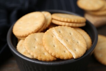 Tasty salty crackers on wooden table, closeup