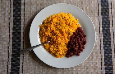 Yellow rice with tuna and red beans on a glass table, typical Costa Rican food