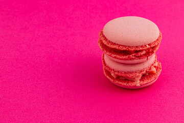 Delicious pink macarons stacked on a vibrant background