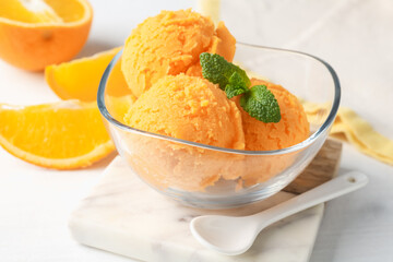 Tasty orange sorbet, fresh fruits and mint on white table, closeup