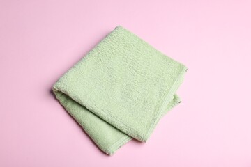Clean towel on pink background, above view