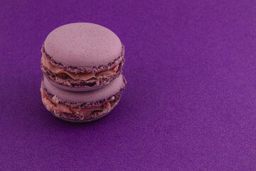 Purple macarons stacked on a vibrant purple background