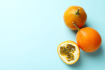 Ripe yellow passion fruits on light blue background, flat lay. Space for text