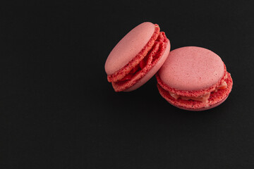 Pink macarons displayed on a black background