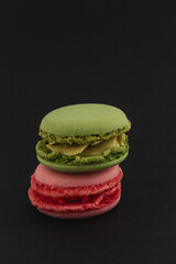 Colorful macarons stacked against a dark backdrop
