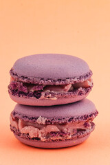 Beautiful purple macarons stacked on an orange background